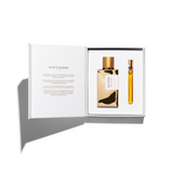 Perfume set with gold bottle and smaller yellow bottle in a white box on a white background